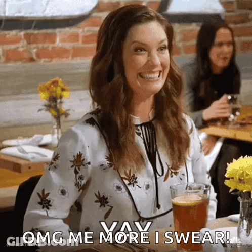 A Woman Is Sitting At A Table With A Glass Of Beer And Smiling While Saying OMG Me More I Swear . GIF