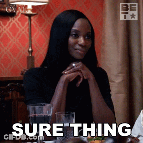 A Woman Is Sitting At A Table With A Glass Of Wine And Says Sure Thing GIF