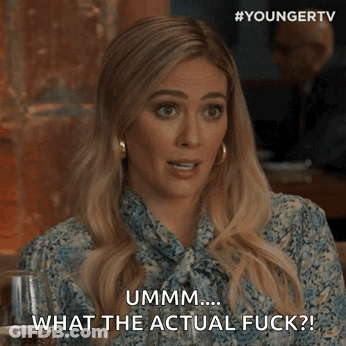 A Woman Is Sitting At A Table With A Glass Of Wine And Says " Ummm What The Actual Fuck " GIF