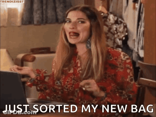 A Woman Is Sitting At A Table With A Laptop And Saying `` Just Sorted My New Bag '' GIF
