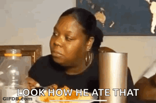 A Woman Is Sitting At A Table With A Plate Of Food And A Bottle Of Water . GIF