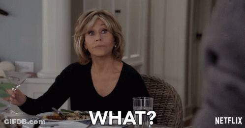 A Woman Is Sitting At A Table With A Plate Of Food And A Glass Of Water And Says What GIF