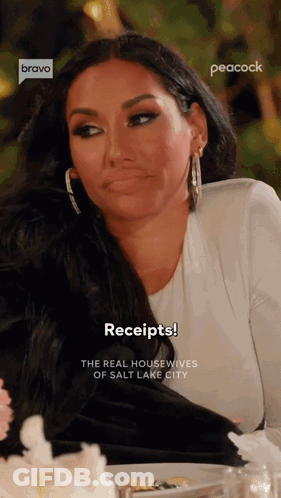 A Woman Is Sitting At A Table With A Plate Of Food And A Peacock Logo Behind Her GIF