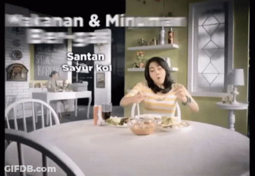 A Woman Is Sitting At A Table With A Plate Of Food And The Words Santan Sayur Kol On The Bottom GIF