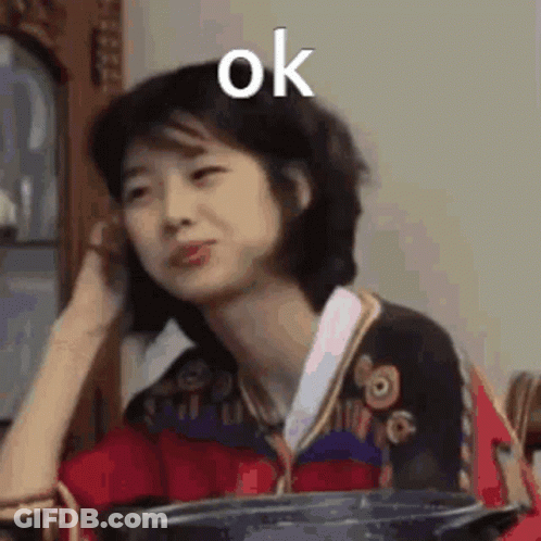 A Woman Is Sitting At A Table With A Pot In Her Hand And Making A Face . GIF