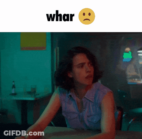 A Woman Is Sitting At A Table With A Sad Face And The Word Whar Behind Her GIF