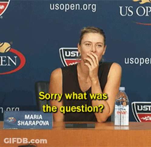 A Woman Is Sitting At A Table With A Sign That Says Maria Sharapova GIF