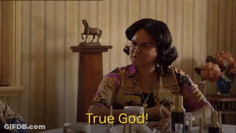 A Woman Is Sitting At A Table With A Statue Of A Horse In The Background . GIF
