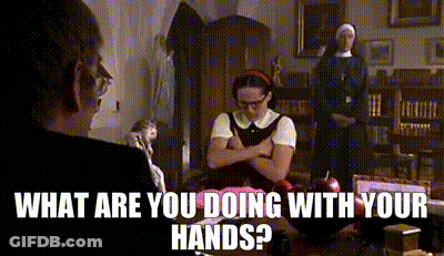 A Woman Is Sitting At A Table With Her Arms Crossed And The Words What Are You Doing With Your Hands Above Her GIF