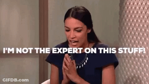 A Woman Is Sitting At A Table With Her Hands Folded And Says `` I 'M Not The Expert On This Stuff ! '' GIF