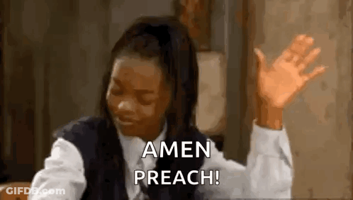 A Woman Is Sitting At A Table With Her Hands In The Air . GIF