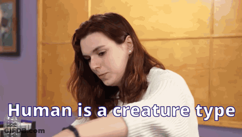A Woman Is Sitting At A Table With The Words Human Is A Creature Type Written On The Bottom GIF