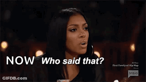 A Woman Is Sitting At A Table With The Words Now Who Said That Above Her GIF