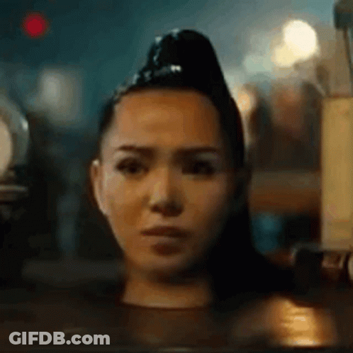 A Woman Is Sitting In A Bathtub With Her Head In The Water And Making A Funny Face . GIF