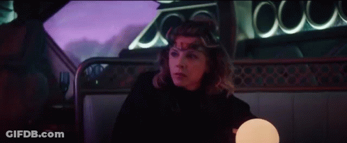 A Woman Is Sitting In A Car With A Crown On Her Head And A Lamp . GIF