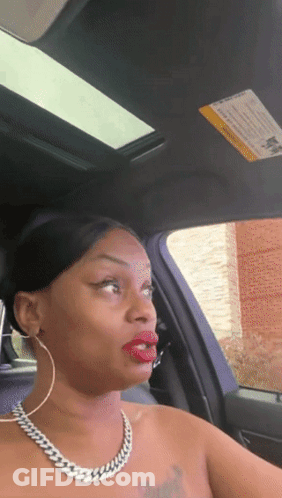 A Woman Is Sitting In A Car With A Warning Sign On The Sunroof GIF