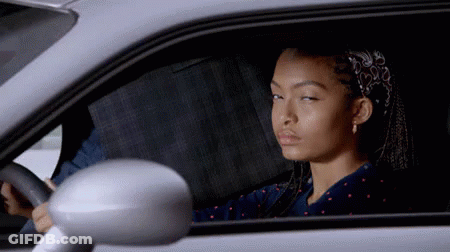 A Woman Is Sitting In A Car With Her Eyes Closed GIF