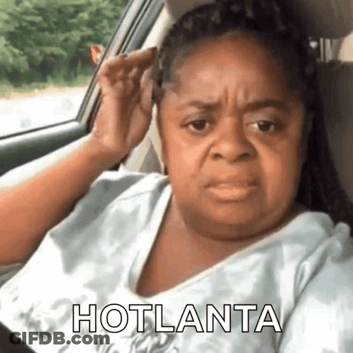A Woman Is Sitting In A Car With Her Hand On Her Ear And The Words Hotlanta Written On The Bottom . GIF