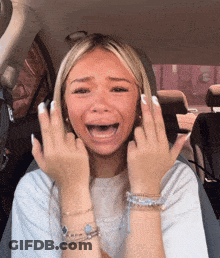 A Woman Is Sitting In A Car With Her Mouth Open GIF