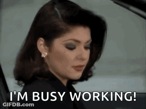 A Woman Is Sitting In A Car With The Words `` I 'M Busy Working '' Written On Her Face . GIF
