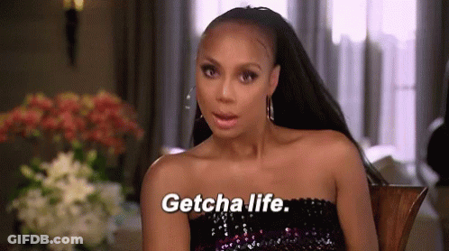 A Woman Is Sitting In A Chair And Saying Getcha Life GIF