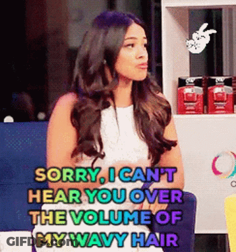 A Woman Is Sitting In A Chair And Says Sorry I Can 'T Hear You Over The Volume Of My Wavy Hair .. GIF