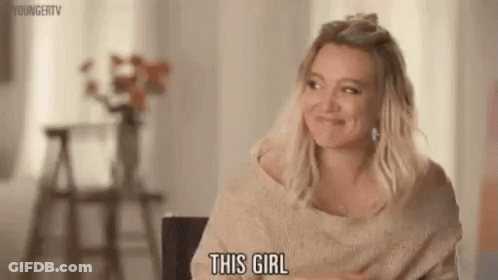 A Woman Is Sitting In A Chair And Smiling While Talking To Someone . GIF