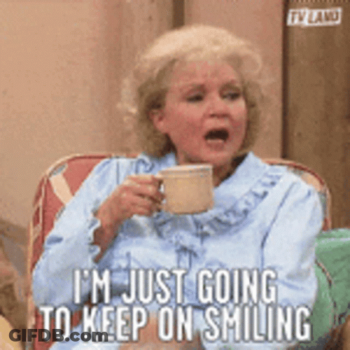 A Woman Is Sitting In A Chair Holding A Cup Of Coffee And Saying I Am Just Going To Keep On Smiling . GIF