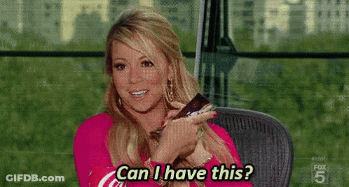 A Woman Is Sitting In A Chair Holding A Remote Control And Asking , Can I Have This ? GIF