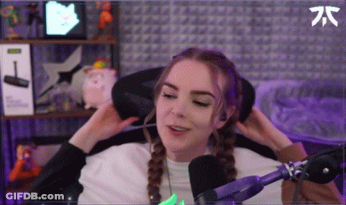 A Woman Is Sitting In A Chair In Front Of A Microphone And Adjusting Her Hair . GIF