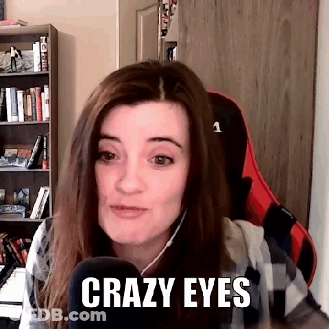 A Woman Is Sitting In A Chair In Front Of A Microphone And Says Crazy Eyes . GIF
