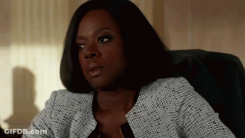 A Woman Is Sitting In A Chair In Front Of A Window And Looking At The Camera . GIF