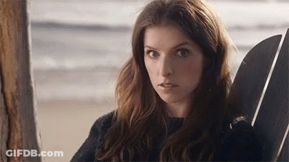 A Woman Is Sitting In A Chair On The Beach With A Surfboard . GIF