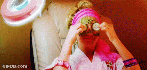 A Woman Is Sitting In A Chair With A Mask On Her Eyes . GIF