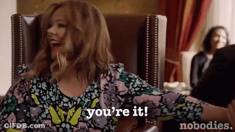 A Woman Is Sitting In A Chair With Her Arms Outstretched And Says `` You 'Re It '' . GIF