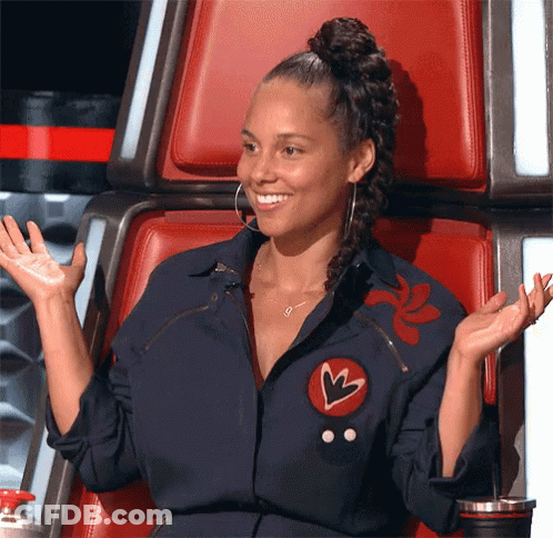 A Woman Is Sitting In A Chair With Her Arms Outstretched And Smiling GIF