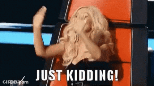 A Woman Is Sitting In A Chair With Her Hands In The Air And The Words `` Just Kidding ! '' Above Her . GIF