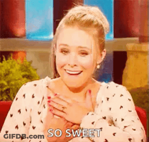 A Woman Is Sitting In A Chair With Her Hands On Her Chest . GIF