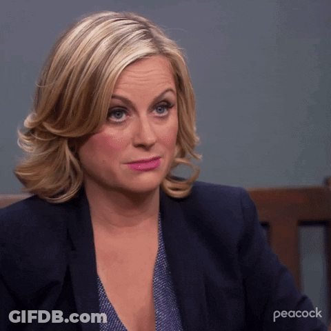 A Woman Is Sitting In A Chair With Peacock Written On The Bottom GIF