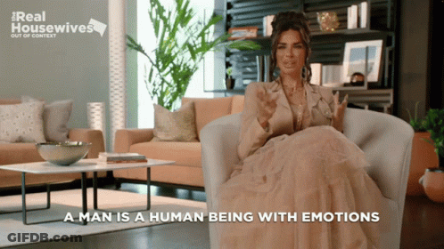 A Woman Is Sitting In A Chair With The Words " A Man Is A Human Being With Emotions " GIF