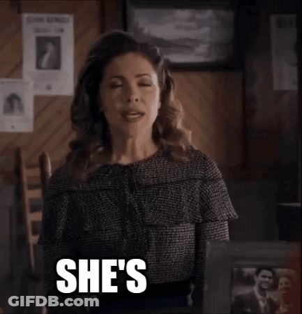 A Woman Is Sitting In A Chair With The Words She 'S Quirky Written On Her Face . GIF
