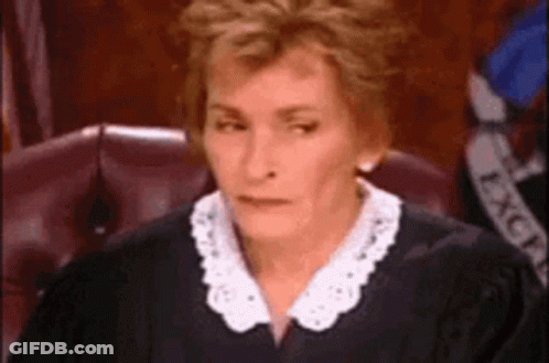 A Woman Is Sitting In A Courtroom Wearing A Judge 'S Robe And A White Collar . GIF