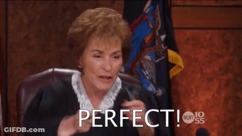 A Woman Is Sitting In A Courtroom With Her Hands In The Air And The Words Perfect Above Her GIF