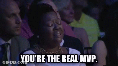 A Woman Is Sitting In A Crowd Of People And Crying . GIF