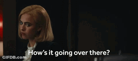 A Woman Is Sitting In A Dark Room Talking To Someone . GIF