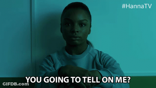 A Woman Is Sitting In A Dark Room With The Words " You Going To Tell On Me " Below Her GIF