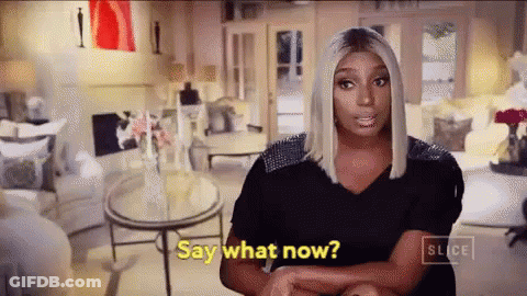 A Woman Is Sitting In A Living Room And Saying " Say What Now " . GIF