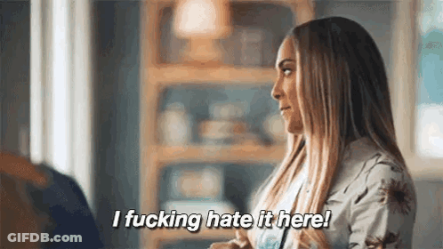 A Woman Is Sitting In A Living Room Talking To A Man And Says `` I Fucking Hate It Here ! '' GIF