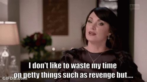 A Woman Is Sitting In A Living Room With A Lamp And A Vase Of Flowers . GIF