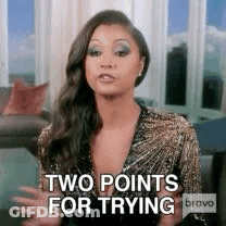A Woman Is Sitting In A Living Room With Her Arms Outstretched And Says `` Two Points For Trying '' . GIF